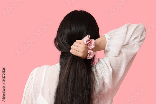 Woman tying hair with silk ...