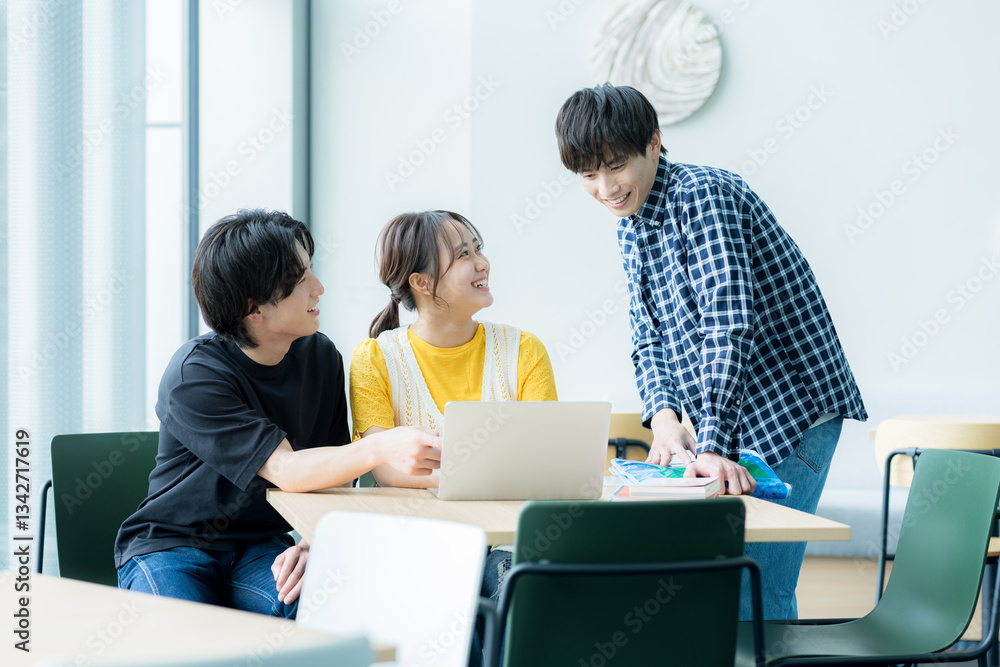 Fototapeta premium パソコンを見ながら話す学生たち【撮影協力:スカパー東京メディアセンター】 