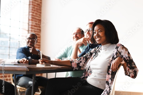 Group of diverse people in a meeting room, smiling and engaged. Bright room, casual attire, teamwork. Diverse group collaborating in a meeting. Business startup team working together on project.
