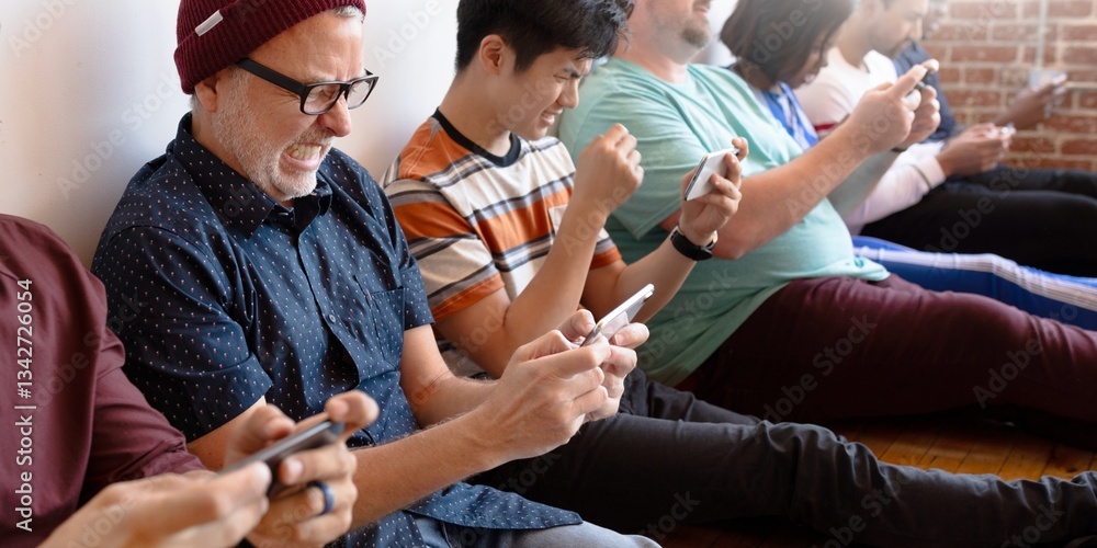 Obraz premium Group of diverse people sitting and using smartphones. Men and women, various ethnicities, all focused on their phones, enjoying digital interaction together. People on their phones, social media.