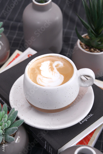 a cup of cappuccino with swan shaped latte art