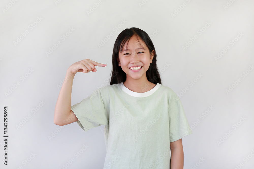 Asian pretty girl with big smile pointing forefinger at her face, teeth or blunt bangs hair on white studio background. Asian pretty girl with big smile pointing forefinger at her face, teeth or blunt bangs hair on white studio background.