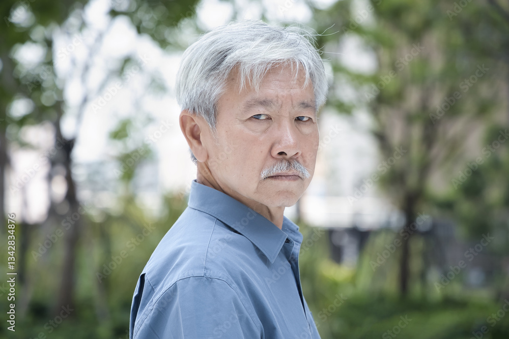 Serious and worried old senior Asian man look back over his shoulder, with bad negative mood Serious and worried old senior Asian man look back over his shoulder, with bad negative mood