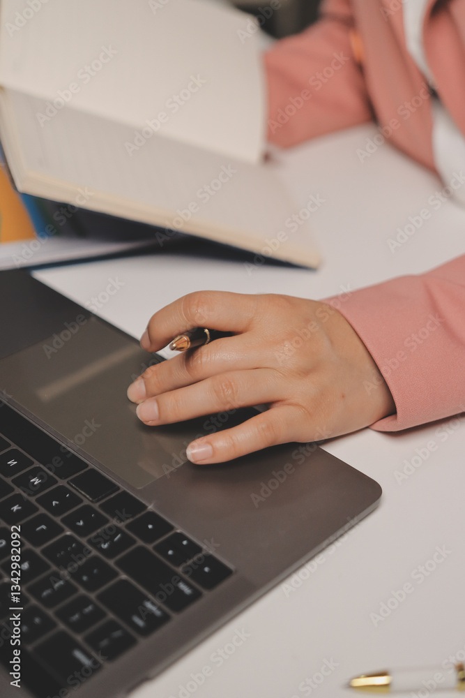 Fototapeta premium Cropped image of professional businesswoman working at her office via laptop, young female manager using portable computer device while sitting at modern loft, flare light, work process concept