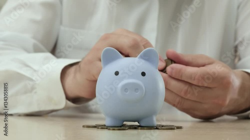 Man putting coins in piggy bank, saving money, investment pension