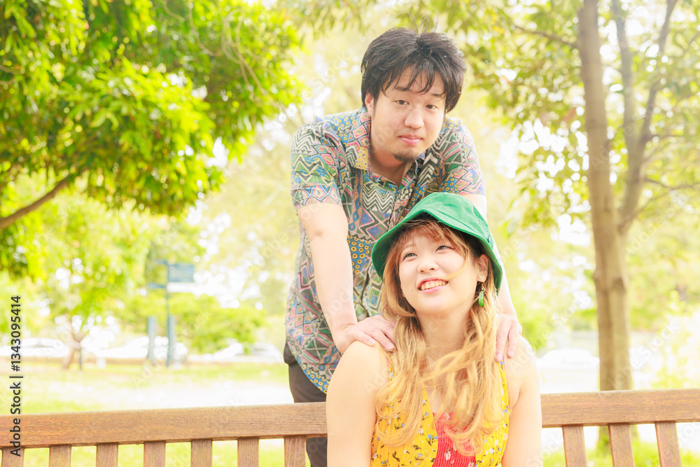 Fototapeta premium ベンチに座る彼女を後ろから抱きしめる彼氏