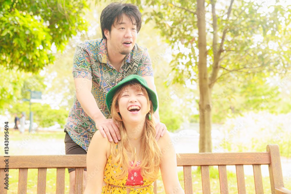 Fototapeta premium ベンチに座る彼女を後ろから抱きしめる彼氏