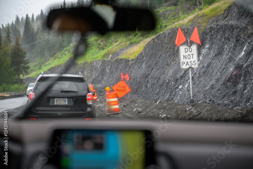 DO NOT PASS and LOOSE GRAVEL road signs along the mountain road. Landslide disaster on the roadside. Alaska. USA.
