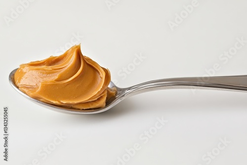 A close up image of creamy peanut butter on a spoon