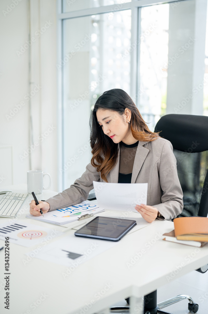Businesswoman or female office worker is holding a pen and writing in document kept in a file folder Businesswoman or female office worker is holding a pen and writing in document kept in a file folder