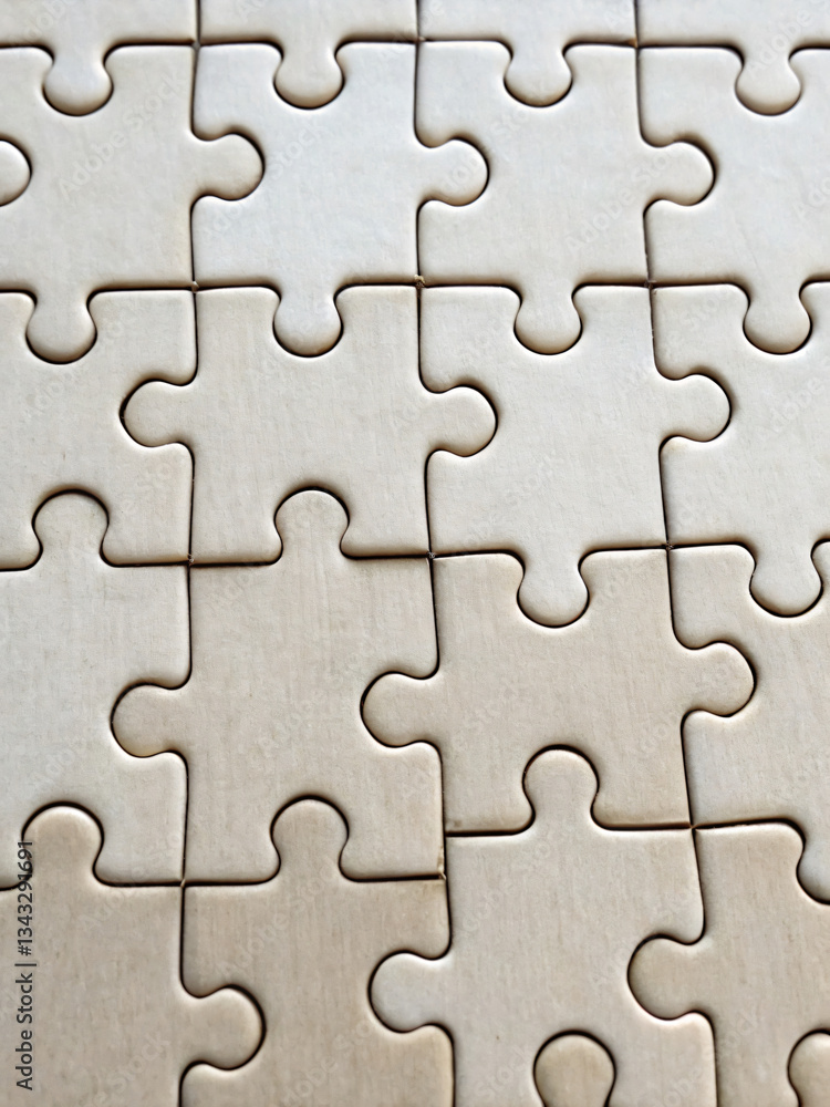 Close-Up View of Interlocking Puzzle Pieces on a Wooden Table Surface Close-Up View of Interlocking Puzzle Pieces on a Wooden Table Surface