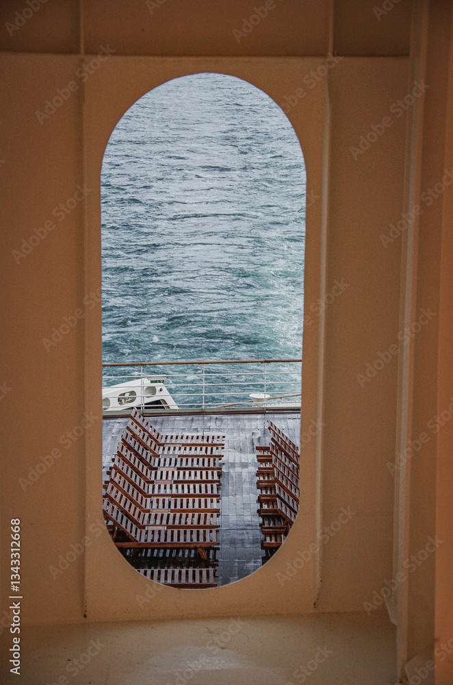 Views onto wet outdoor teak balcony terrace veranda promenade boat deck of ocean liner cruiseship cruise ship with chairs and loungers at sea during Transatlantic Crossing to New York