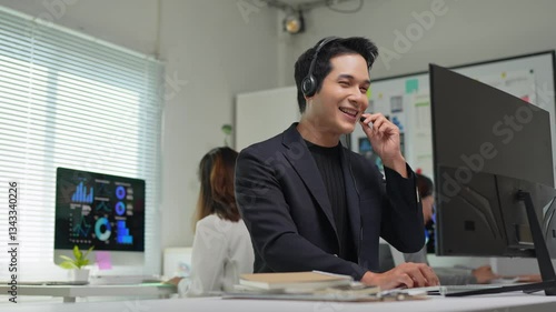 Asian telemarketer working on computer in office