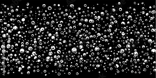 Mesmerizing dance of water bubbles floating against a dark background under soft light