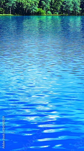Tranquil blue lake reflecting vibrant greenery under a clear sky, ideal for relaxation