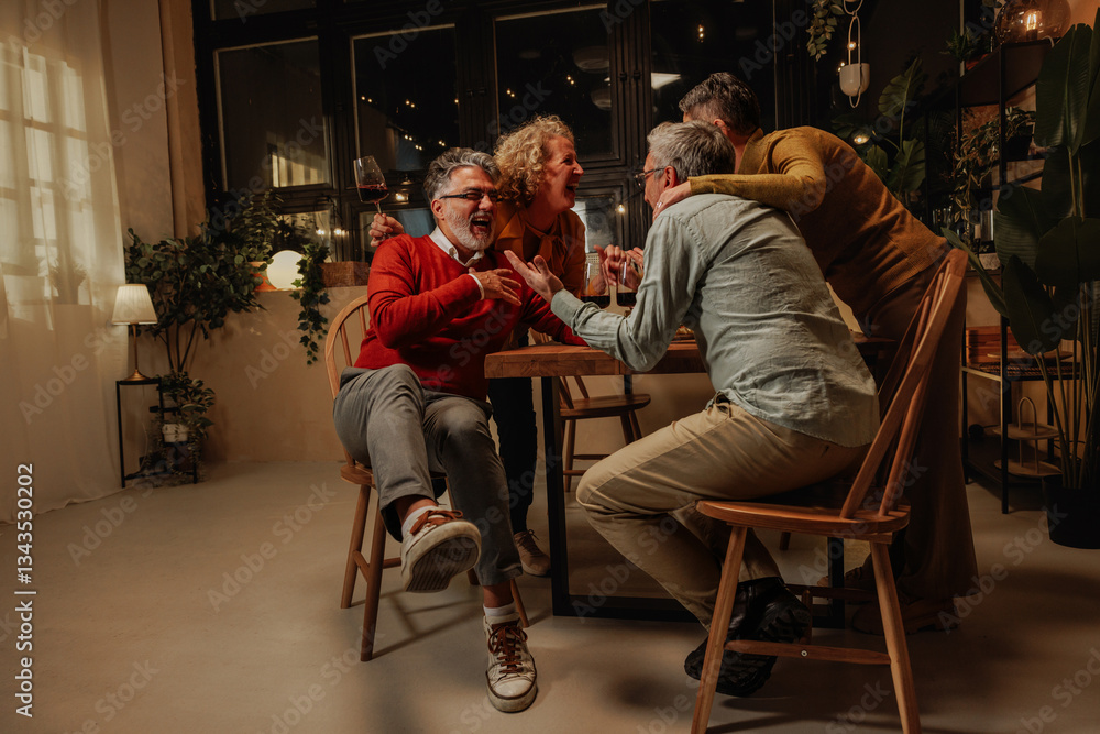 Obraz premium Group of senior friends laughing and having fun celebrating pension at home