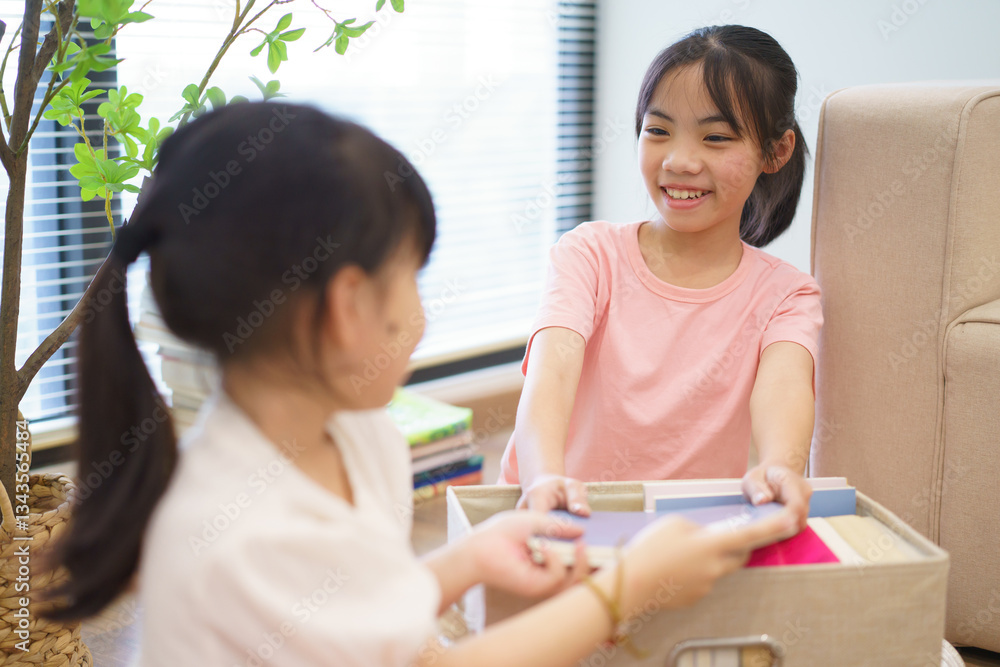 Two young girls engaging in a creative activity while organizing colorful materials in a cozy indoor setting Two young girls engaging in a creative activity while organizing colorful materials in a cozy indoor setting