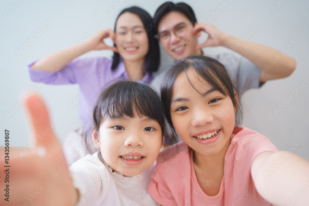 Family enjoying a cheerful moment together indoors while taking a selfie with vivid smiles and playful expressions Family enjoying a cheerful moment together indoors while taking a selfie with vivid smiles and playful expressions