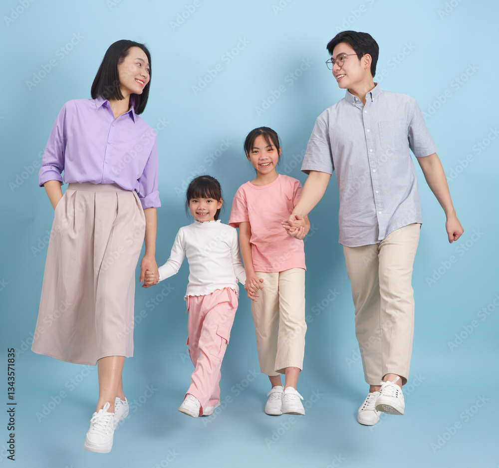 Family enjoys a joyful moment together while walking hand in hand in a bright and colorful indoor setting Family enjoys a joyful moment together while walking hand in hand in a bright and colorful indoor setting