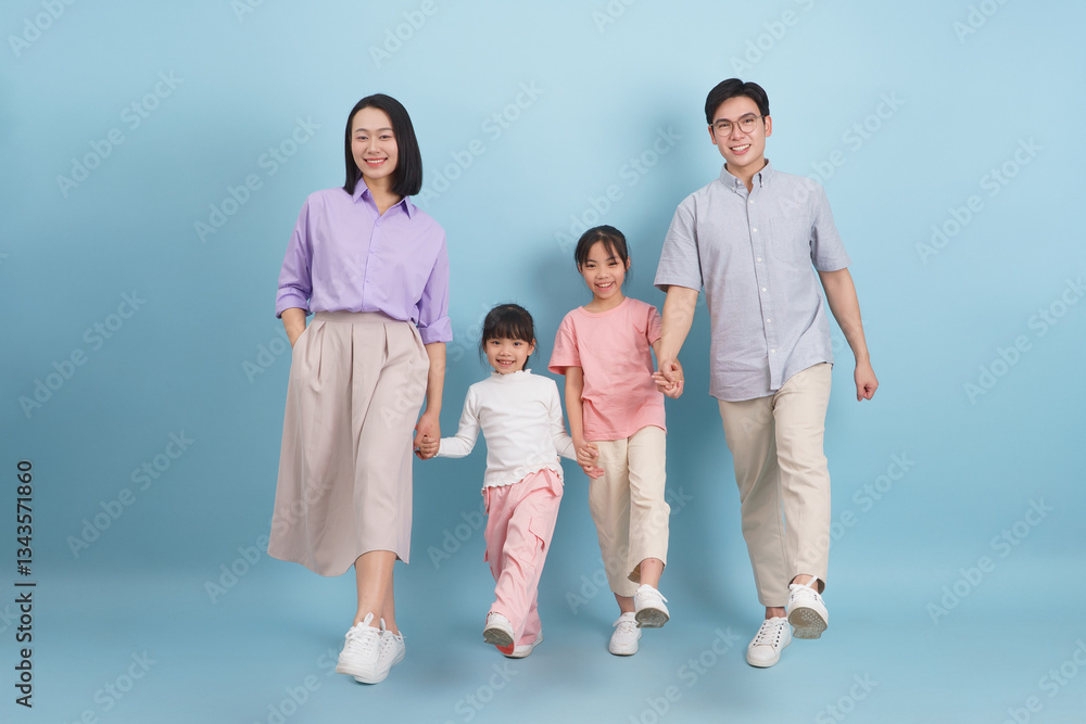 Family walks together in stylish matching outfits against a light blue background during a cheerful day at home Family walks together in stylish matching outfits against a light blue background during a cheerful day at home