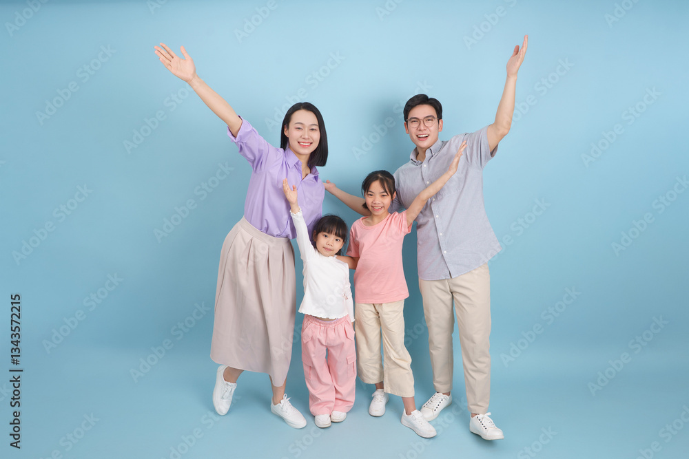 Happy family celebrating together in a cheerful indoor studio setting with a blue background Happy family celebrating together in a cheerful indoor studio setting with a blue background