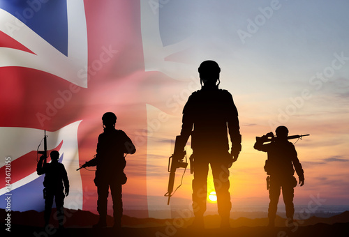 Fotografía Silhouettes of a soldiers with United Kingdom flag against the sunset
