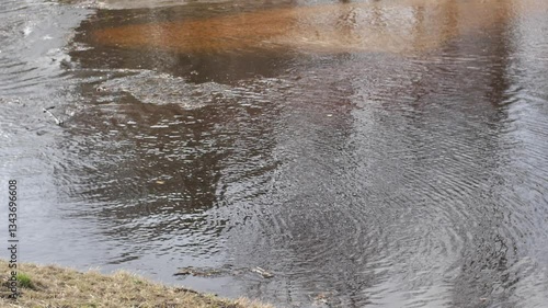 Pieces of ice float gently on a river, creating a tranquil and natural winter scene. The calm water reflects the cold, peaceful atmosphere of the season.