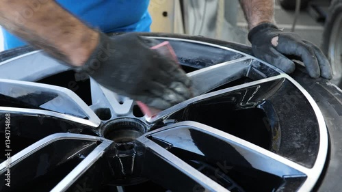 Refurbishing car wheel, hand working on rim with tools, close-up of automotive wheel restoration process, detail, and automotive repair