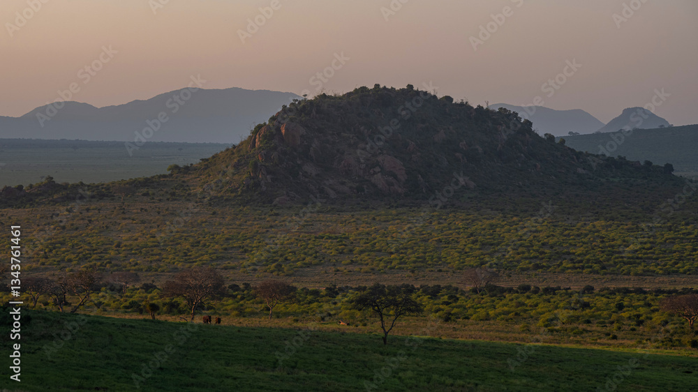 koniec dnia, słońce za horyzontem ostatnimi promieniami oświetla Park Narodowy Tsavo i rezerwat wzgórz Taita, Kenia, Afryka
