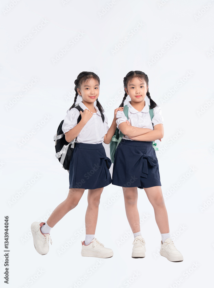 Two young students pose in school uniforms, ready for learning and new adventures with their backpacks. Two young students pose in school uniforms, ready for learning and new adventures with their backpacks.
