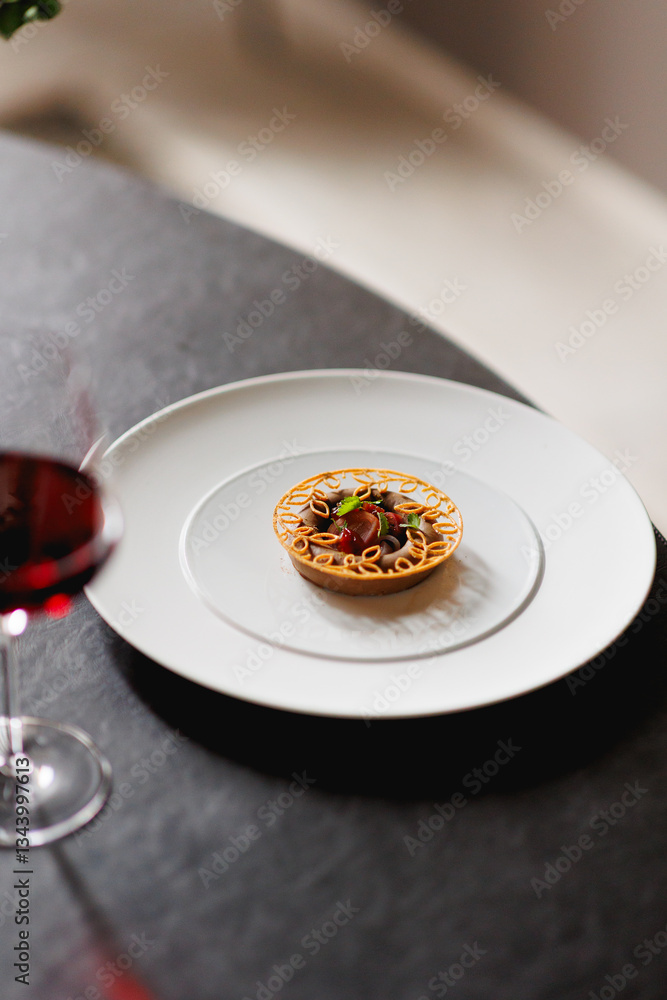 close up view of haute cuisine starter appetiser liver pate on a white plate on grey stone background with a glass of red appropriate wine close up view of haute cuisine starter appetiser liver pate on a white plate on grey stone background with a glass of red appropriate wine