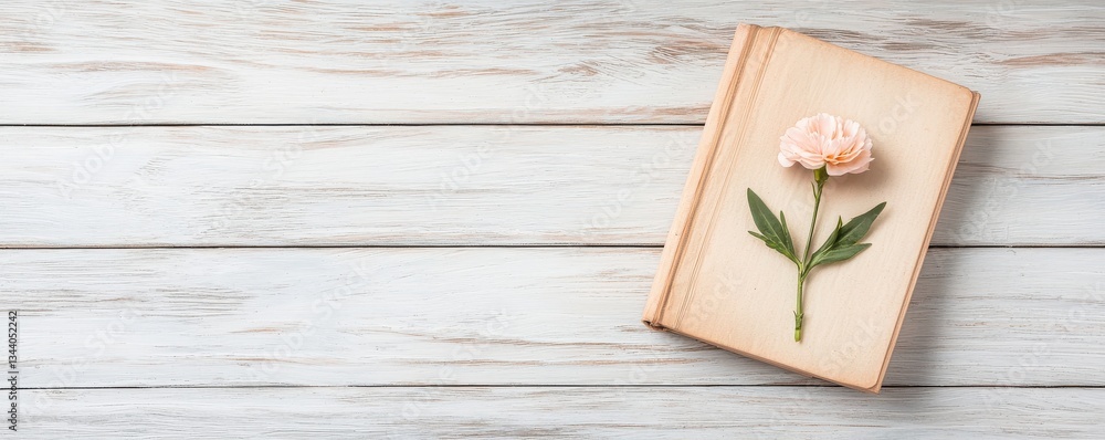 A delicate flower lies on an open book against a rustic wooden background, creating a serene and artistic atmosphere. A delicate flower lies on an open book against a rustic wooden background, creating a serene and artistic atmosphere.