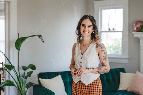 фотографія Young Tattooed Woman Standing in a Living Room