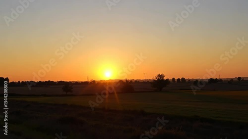 Wallpaper Mural Vibrant Orange and Yellow Sunset over a Tranquil Green Field Torontodigital.ca