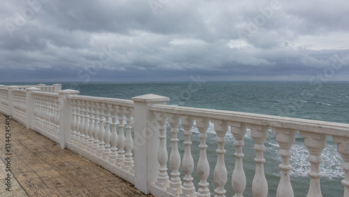 A parapet on the embankment for walking by the sea. Inclement weather on the Black Sea. Thunderclouds and a storm at sea. A recreation area by the sea.