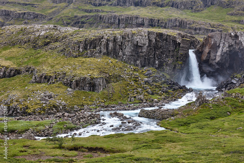 Obraz na płótnie Waterfall and basalt rocks covered by moss. Seydisfjordur. Iceland w salonie