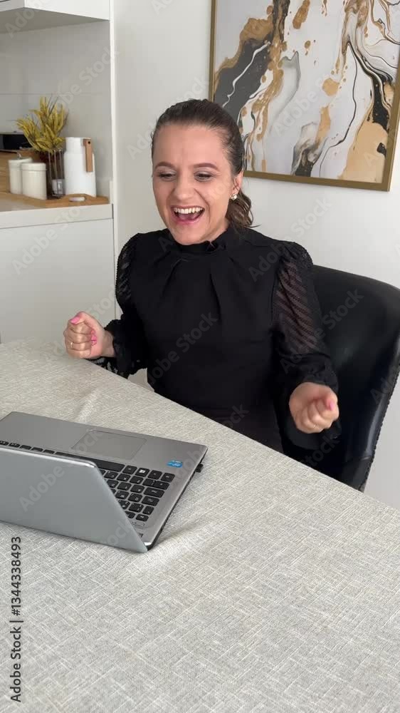 Mulher feliz com os negócios em frente a computador portatil em casa