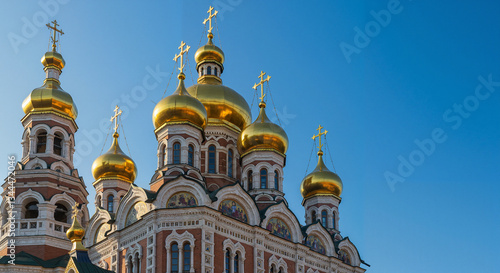 Golden Domes of an Orthodox Church, traditional architectural style, against a clear blue sky