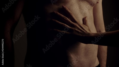Female hand touching male muscular torso. Slow motion