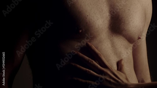 Female hand touching male muscular torso. Slow motion