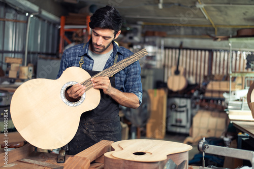Luthier making top of guitar using traditional tools in workroom with manual tools