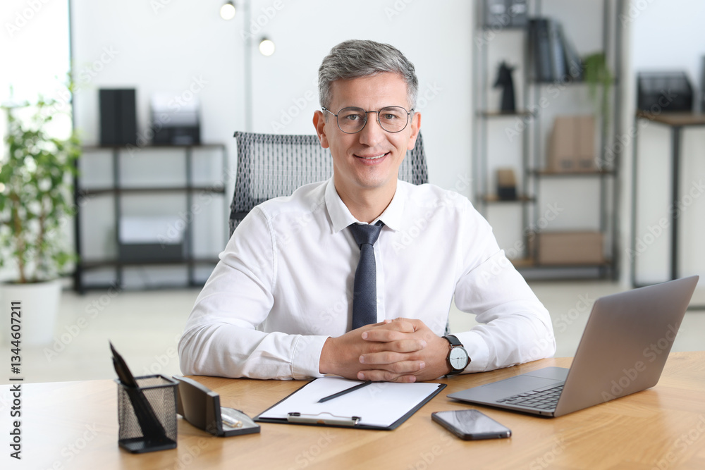 Portrait of businessman at table in office Portrait of businessman at table in office