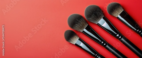 Makeup Brushes Arranged Neatly on a Vibrant Red Background for Beauty Applica...