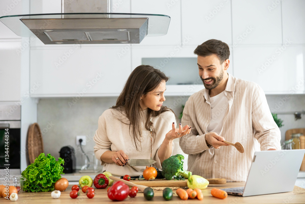 The couple shows curiosity and interest while pondering over a recipe, surrounded by fresh vegetables in the kitchen. The couple shows curiosity and interest while pondering over a recipe, surrounded by fresh vegetables in the kitchen.