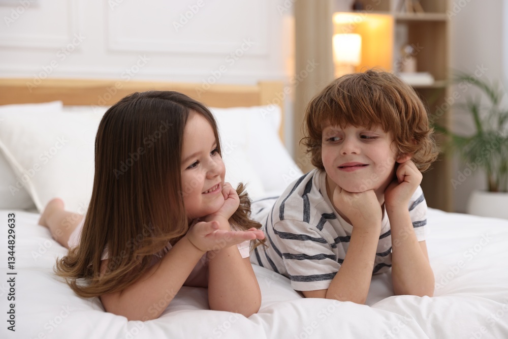 Happy children wearing pajamas on bed at home Happy children wearing pajamas on bed at home