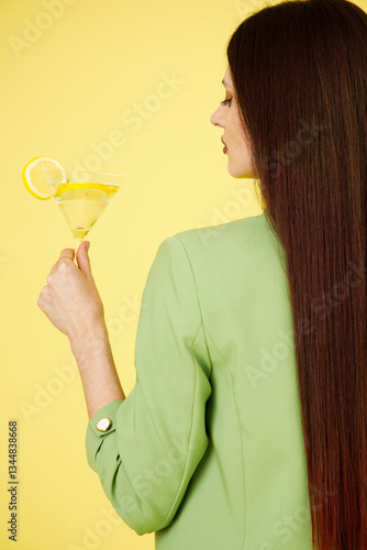 Obraz na płótnie Fashion portrait of beautiful model in green suit with glass of lemonade against yellow background w salonie