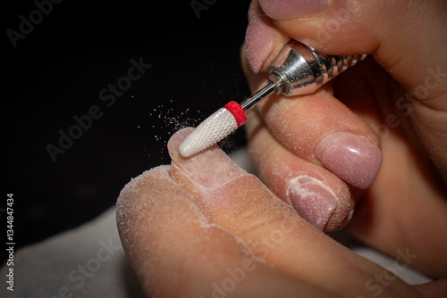 Nail Technician Using Electric Nail Drill for Manicure and Nail Care