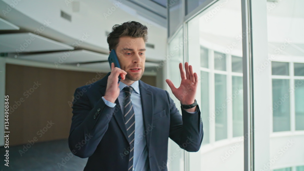 Angry boss shouting cellphone walking modern office hallway closeup. Nervous man Angry boss shouting cellphone walking modern office hallway closeup. Nervous man