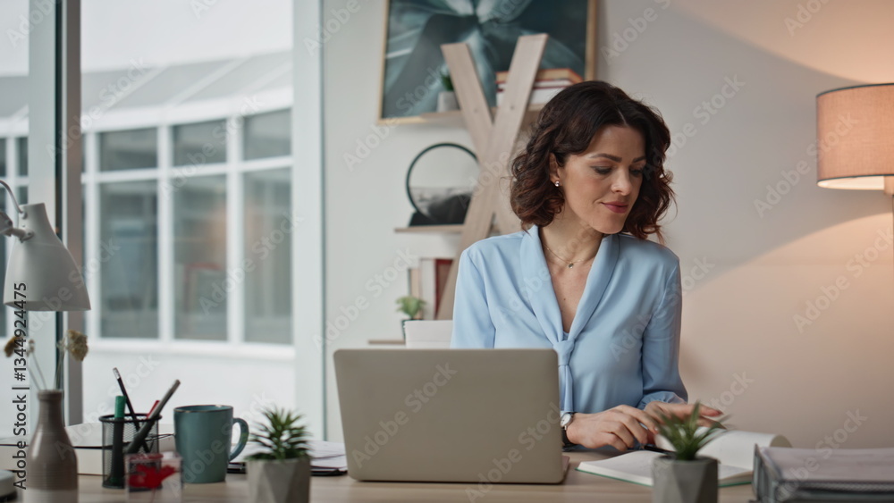 Multitasking woman working office desk with laptop reading notebook closeup Multitasking woman working office desk with laptop reading notebook closeup