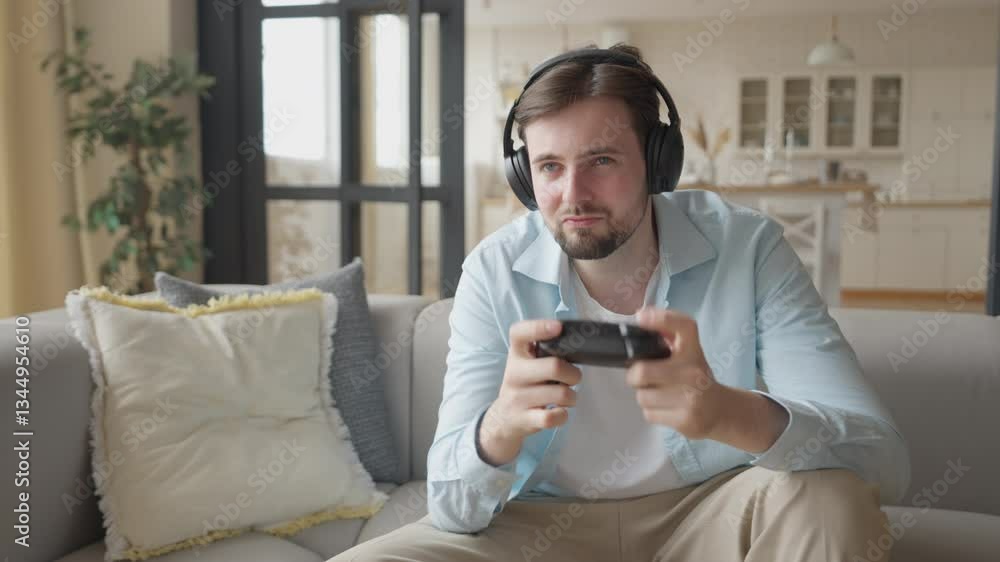 Guy in Headphones Playing Console Game on Sofa Frustrated After Losing the Match Guy in Headphones Playing Console Game on Sofa Frustrated After Losing the Match